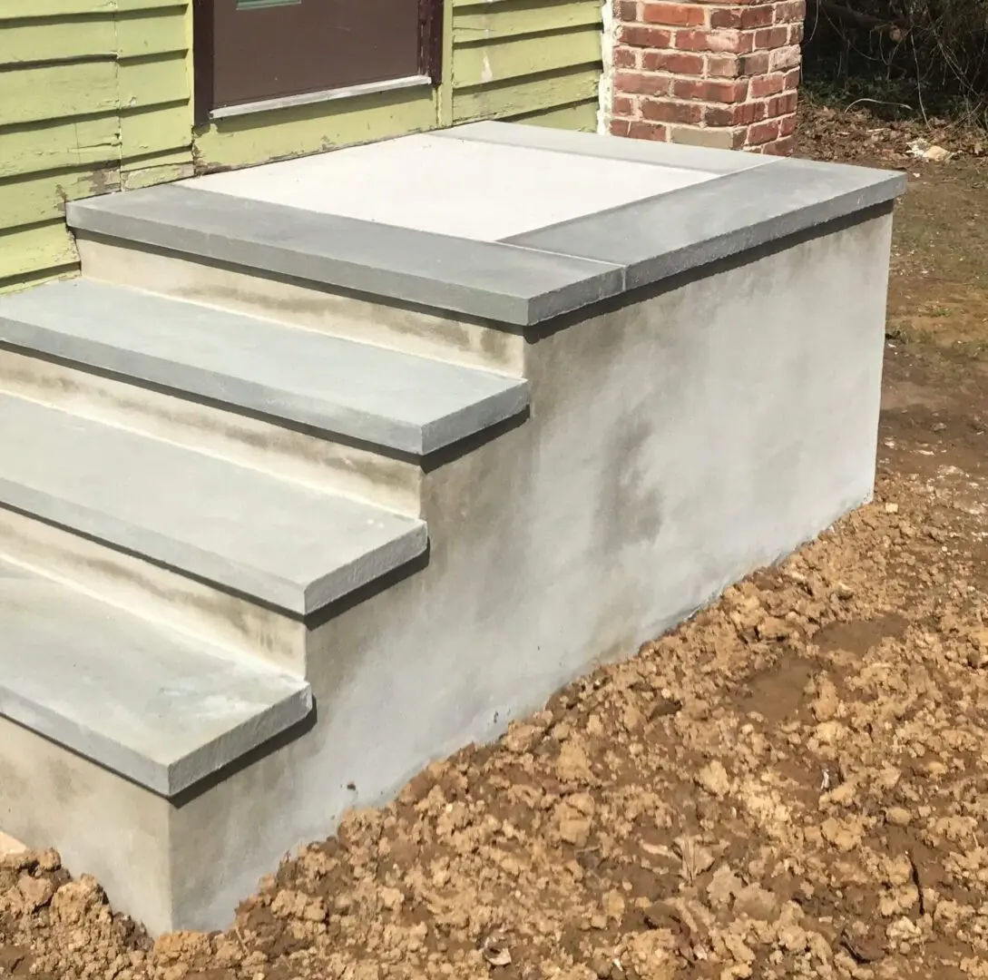 Concrete steps with a smooth finish leading to a raised platform.