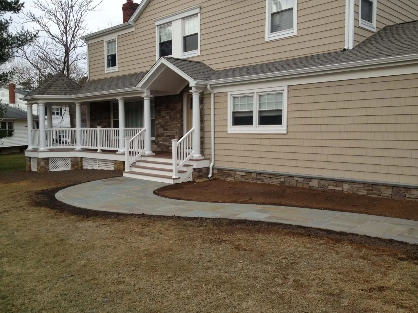 Newly poured concrete walkway around a house's front porch.