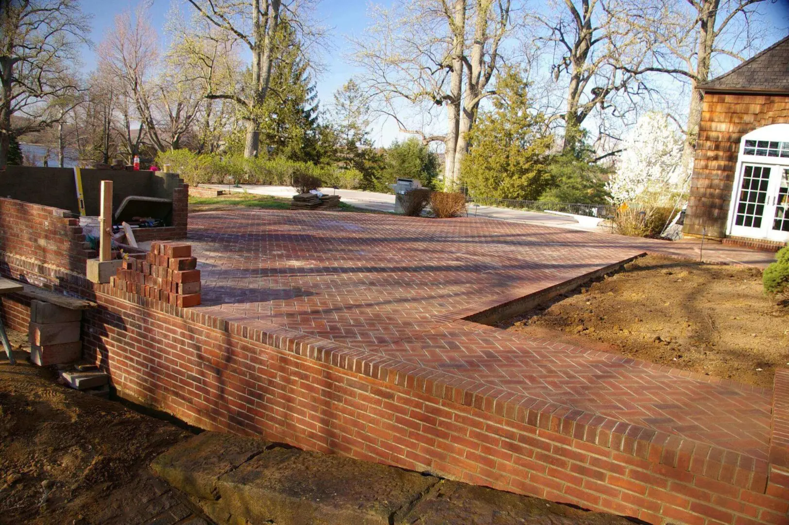 A wooden deck under construction in a backyard surrounded by trees.
