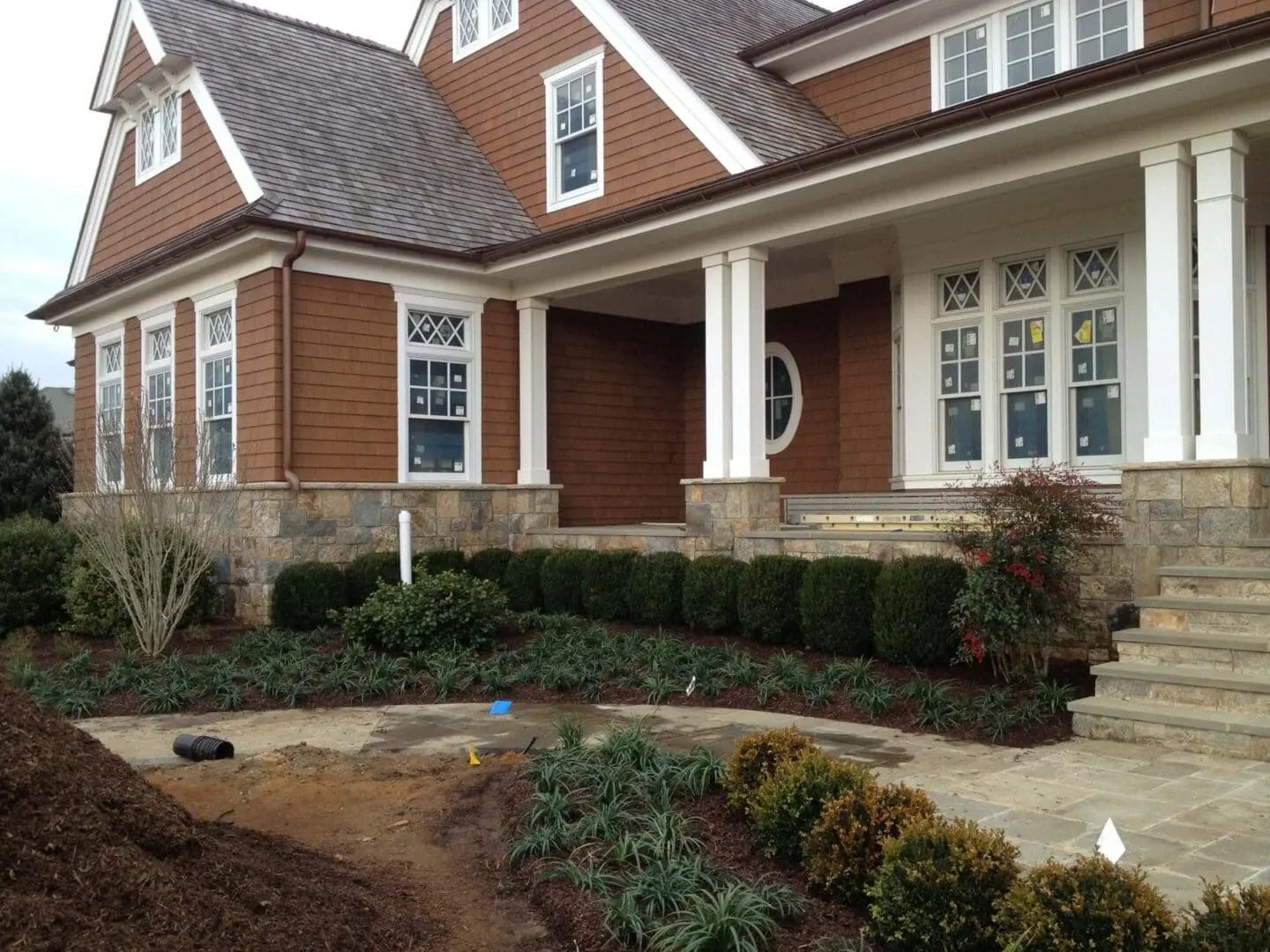 A charming brick house with a manicured front yard and a covered porch.