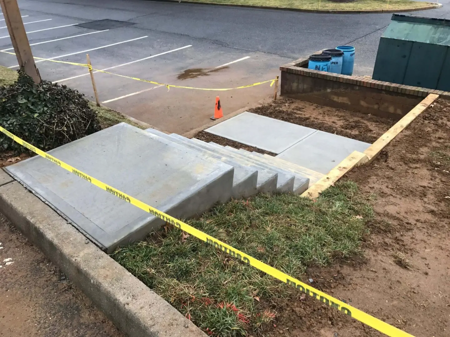 Newly constructed concrete stairs with measuring tape across the grass.
