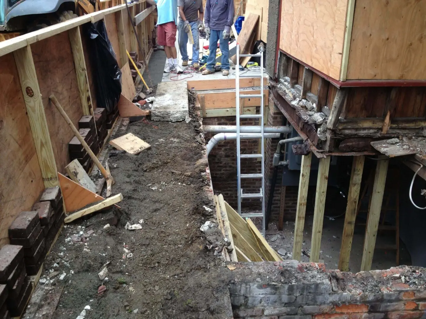Construction site with foundation work and people observing.