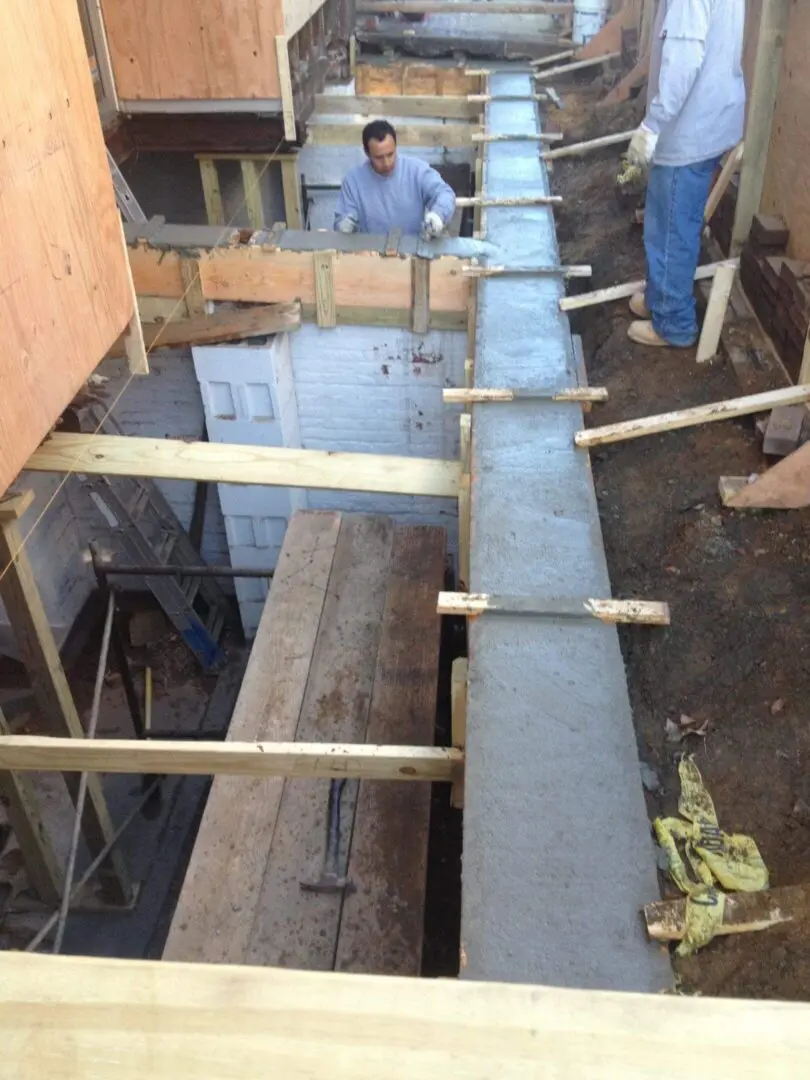 Concrete poured into a wooden frame for a building foundation.