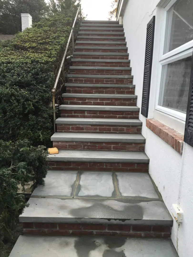 Brick stairs with a concrete landing and a small pumpkin on the steps.