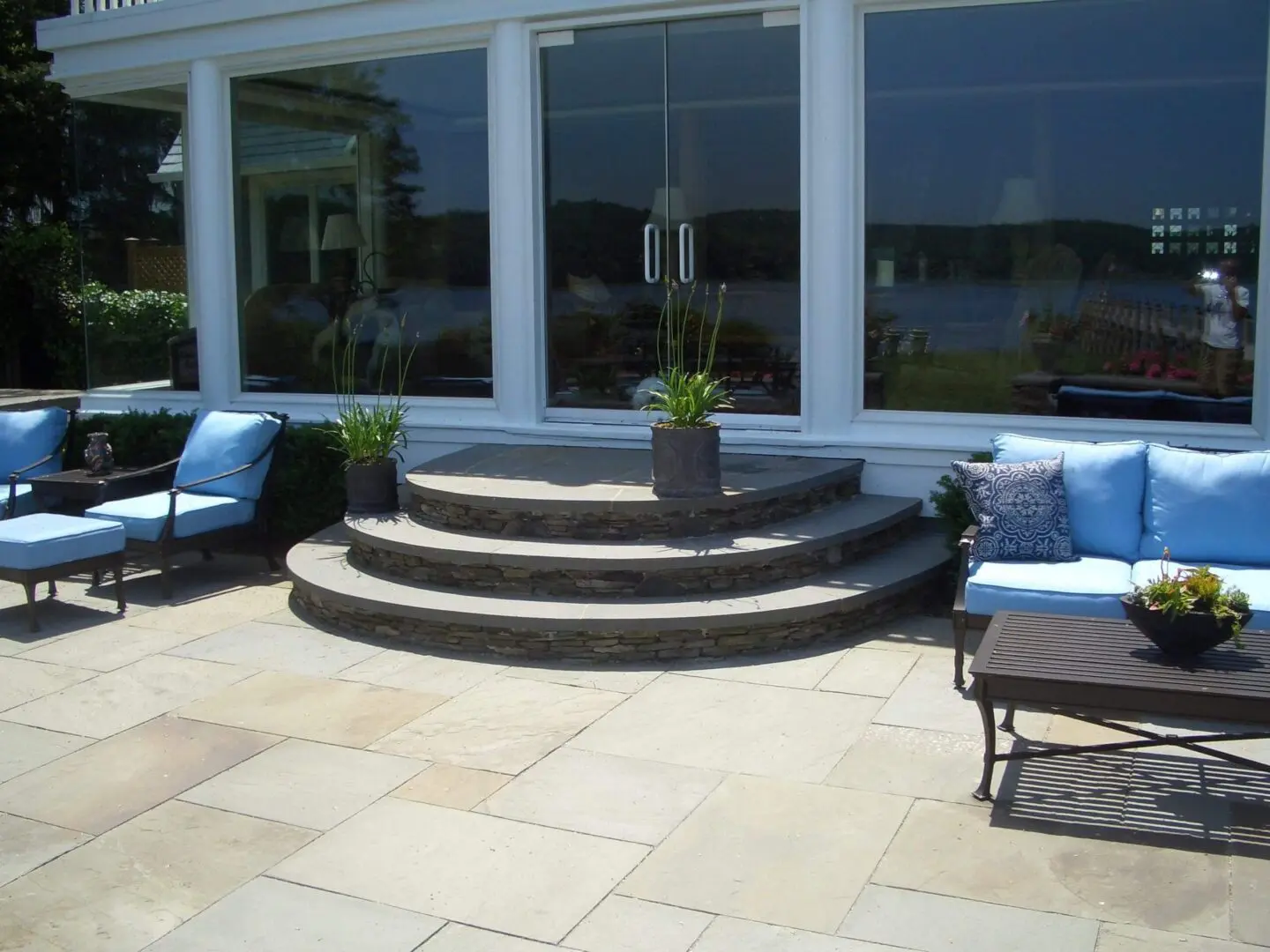 Elegant circular stone steps leading to a glass door on a patio.