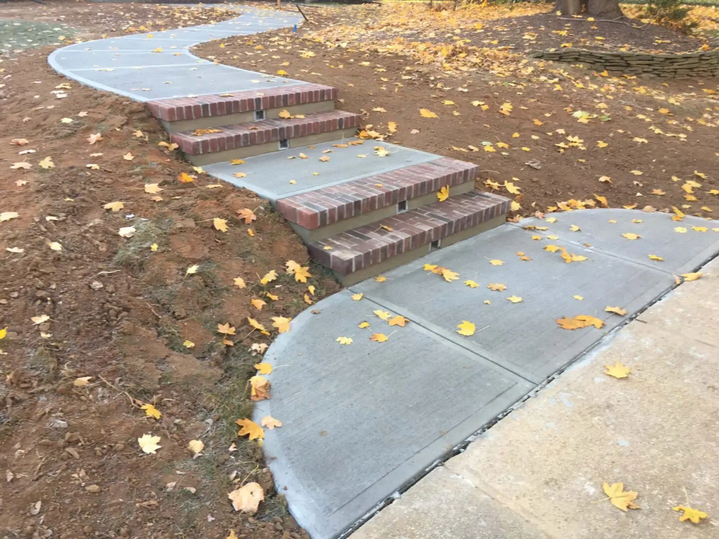 Concrete steps with fallen autumn leaves scattered around.
