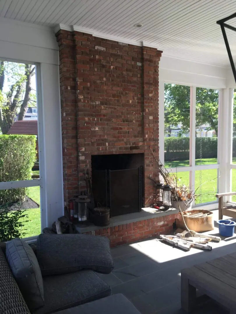 Cozy brick fireplace with large windows letting in natural light.