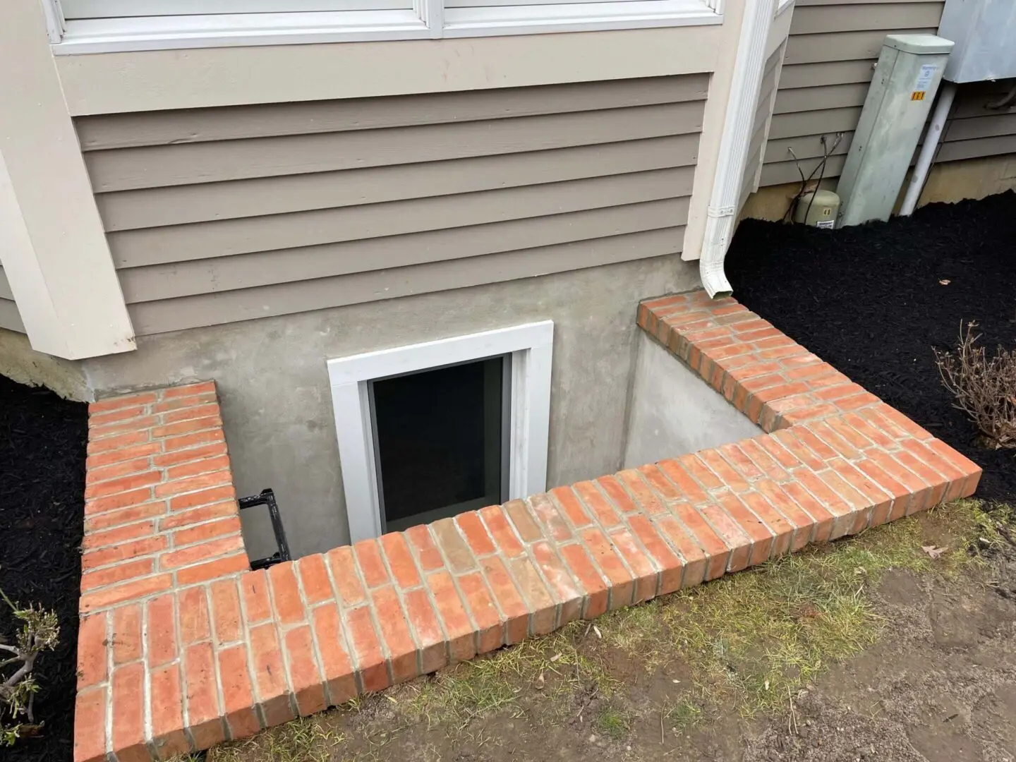 A small pet door installed on a building's exterior wall.