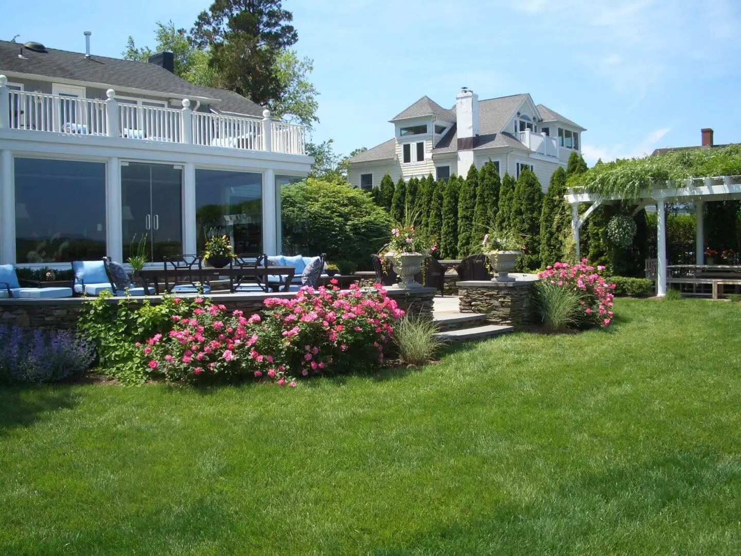 Beautiful backyard with lush lawn and blooming flowers near a modern house.