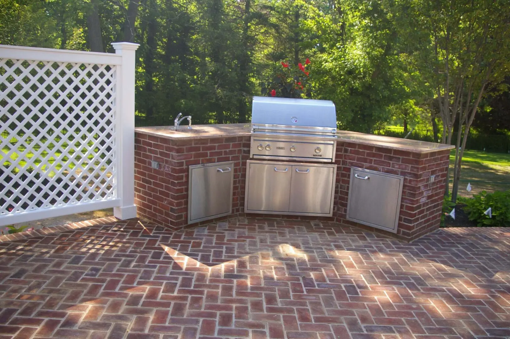 Outdoor brick grill setup with stainless steel appliances.