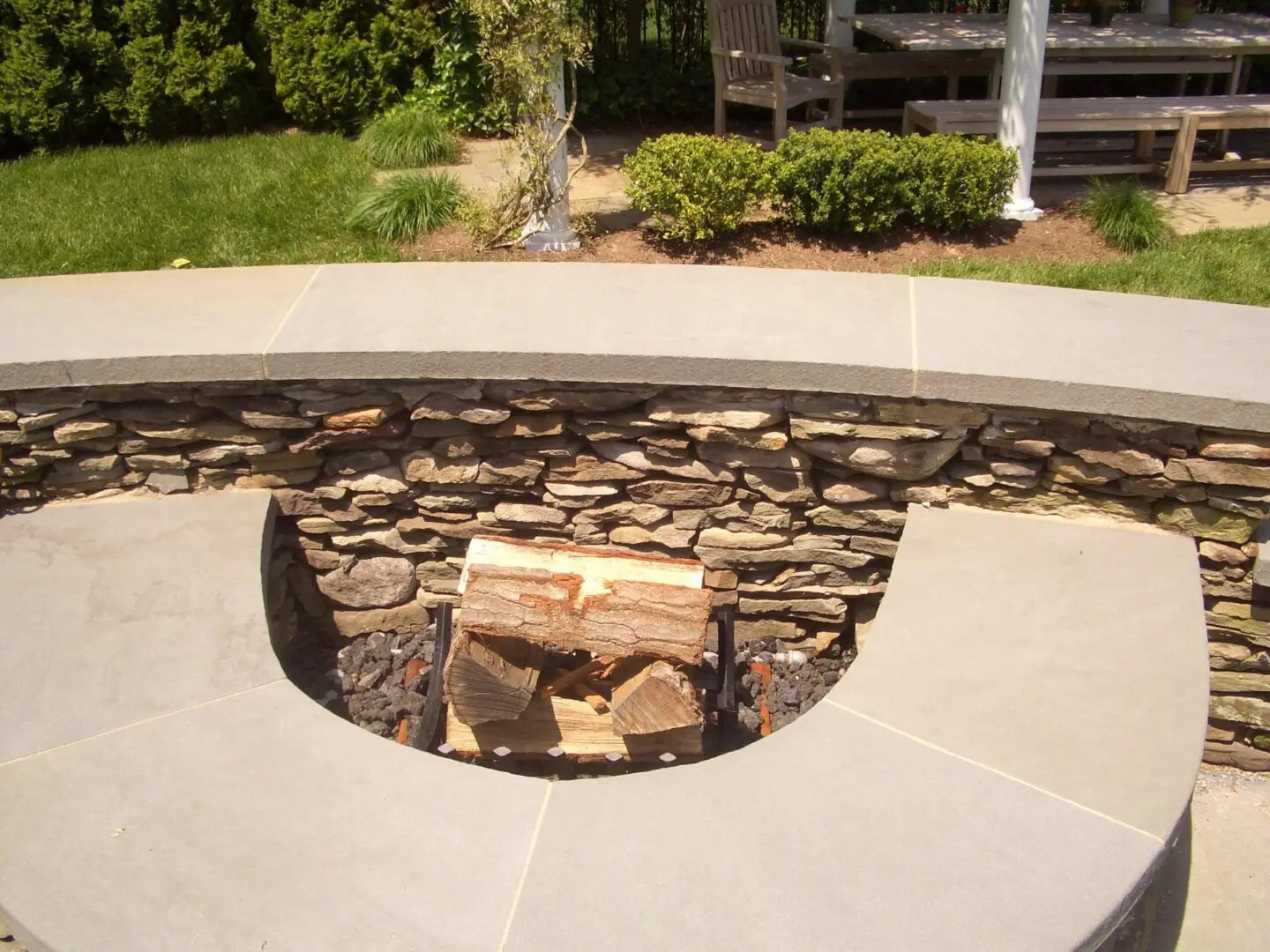 A stone fire pit with a circular seating area outdoors.