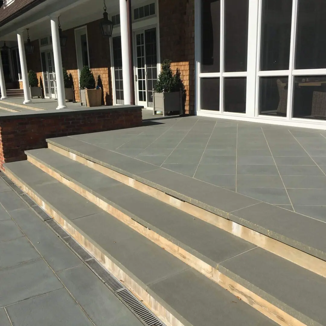 Stone steps leading up to a building entrance with large windows.
