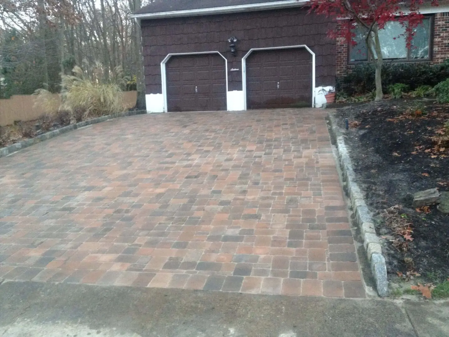 Newly paved brick driveway leading to a two-car garage.