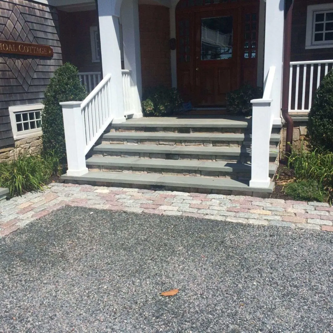 Front porch with stone steps leading to a wooden door.